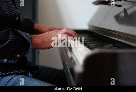 Jeune homme jouant du piano. Tourné à partir d'une vue basse côté ; mettre l'accent sur mans mains sur les touches Banque D'Images