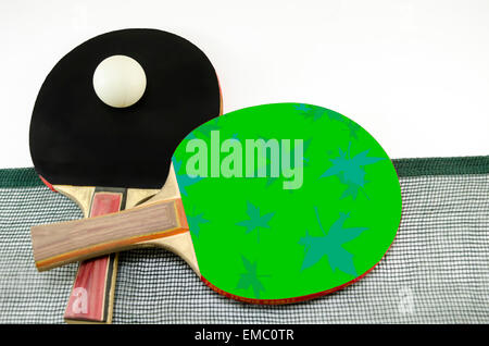 Deux raquettes de tennis de table l'une sur l'autre et d'un vieux white net. Une palette est vert et l'autre est noir Banque D'Images