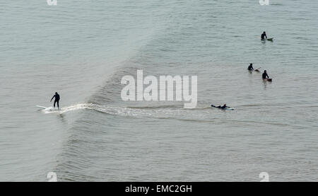 Manèges d'un surfer une vague d'un ensemble à Saunton beackh sur un longboard, Devon, UK Banque D'Images