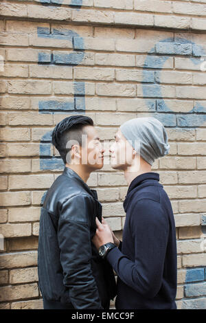 La Chine, Hong Kong, couple gay au mur de la maison Banque D'Images