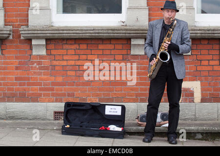 Un musicien ambulant de rue jouant un saxophone ténor Banque D'Images