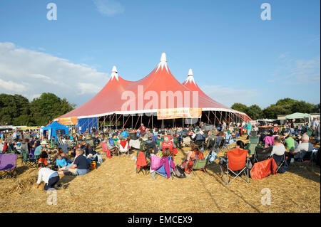 Des gens assis profitant du soleil du soir en face de la scène principale au Festival de musique de Wickham, Hampshire, Angleterre Banque D'Images