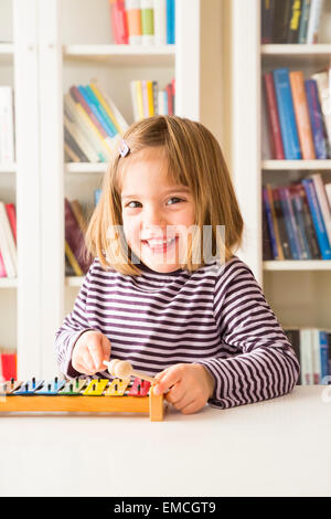 Portrait of happy little girl playing xylophones Banque D'Images