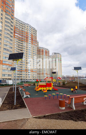 Une aire de jeux pour enfants dans la cour d'un immeuble avec des panneaux solaires Banque D'Images