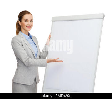 Smiling businesswoman standing next to flipboard Banque D'Images