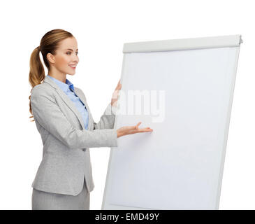 Smiling businesswoman standing next to flipboard Banque D'Images