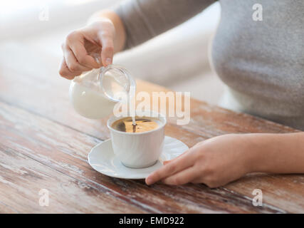 Portrait de femme versant du lait dans le café Banque D'Images