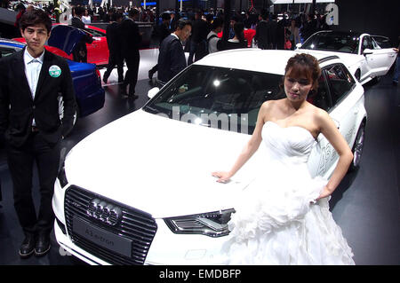 À Shanghai, le Shanghai, Chine. Apr 20, 2015. Stand des modèles par un véhicule affiche dans l'Auto Shanghai 2015, Shanghai, la Chine orientale, le 20 avril 2015. Un total de 1 343 véhicules complets étaient sur l'affichage, y compris 103 nouveaux véhicules de l'énergie et de 47 concept cars. Source : Xinhua/Alamy Live News Banque D'Images