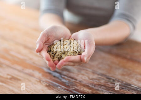 Femme en blanc et riz noir sauvage sur palm Banque D'Images