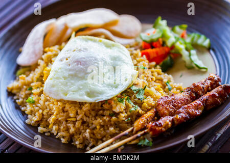 Nasi goreng (riz frit avec recette traditionnelle, œuf frit, de crevettes et de la viande sur des stries ou des membres). Banque D'Images