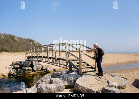 Personne Senior marche sur chemin passerelle au-dessus de la côte du Pays de Galles Nicholaston comprimé flux en Oxwich National Nature Reserve sur la péninsule de Gower Wales UK Banque D'Images