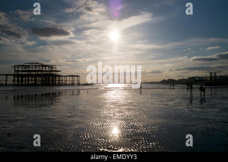 Les gens sur la plage à marée basse, West Pier de Brighton, Royaume-Uni, coucher du soleil, Banque D'Images