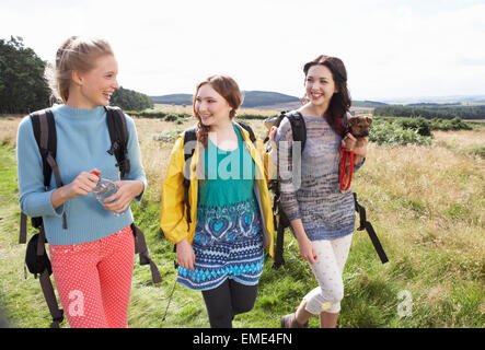 Groupe d'adolescentes en randonnée dans la campagne Avec chien Banque D'Images