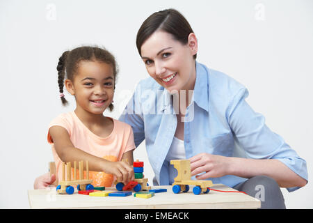 Professeur et élève préscolaire jouer avec maison en bois Banque D'Images