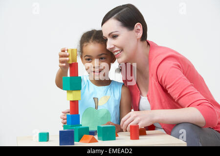 Professeur et élève préscolaire en jouant avec des blocs en bois Banque D'Images