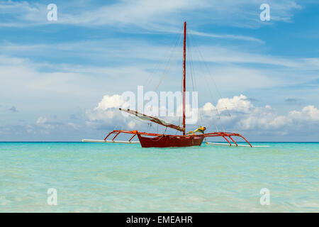 Belle vue sur la mer et bateau à voile rouge et gros nuages blancs sur le premier plan Philippines Boracay Island Banque D'Images