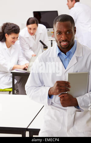 Portrait de technicien en laboratoire avec des collègues Banque D'Images