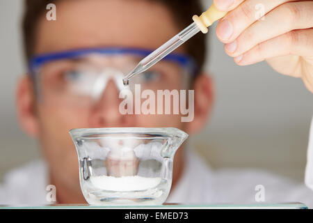 L'ajout d'un scientifique liquide à plat en verre de compte-gouttes Banque D'Images