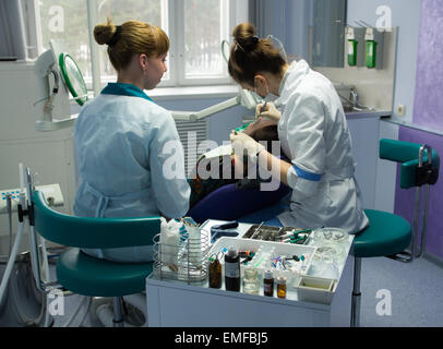Le médecin l'stomatologist et son assistant derrière travailler avec le patient dans un bureau. Banque D'Images