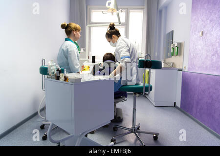 Le médecin l'stomatologist et son assistant derrière travailler avec le patient dans un bureau. Banque D'Images