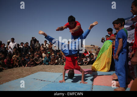 Herat, Afghanistan. Apr 20, 2015. Les enfants déplacés afghans recueillir pendant que les enfants de Mini Mobile pour les enfants du cirque (MMCC) effectuer à un camp de personnes déplacées dans la province de Herat, Afghanistan, le 20 avril 2015. Credit : Ahmad Massoud/Xinhua/Alamy Live News Banque D'Images