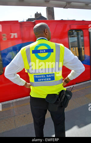 Docklands Light Railway plate-forme travail collègue Voyage Safe Officer haute vis la plate-forme de la gare des chemises DLR train arrive Shadwell East London Angleterre Royaume-Uni Banque D'Images