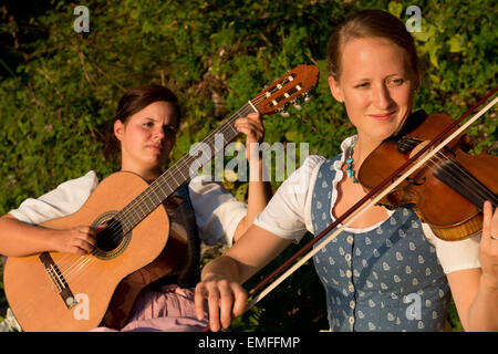 Deux jeunes filles en costumes traditionnels de la lecture de musique, Altaussee, Styrie, Autriche Banque D'Images