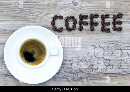 Tasse à expresso avec texte rempli de fèves de café au-dessus Banque D'Images