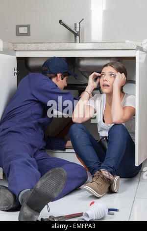 Plombier travaillant sur la cuisine Banque D'Images