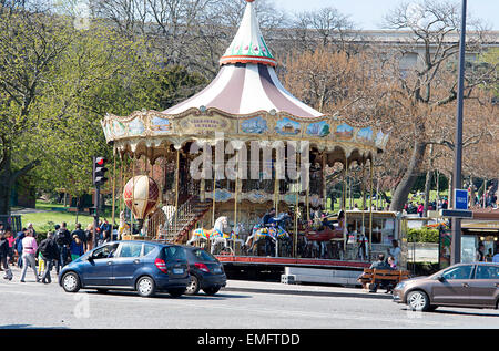 Les touristes visitent un parc et merry-go-round de l'autre côté de la Seine de la Tour Eiffel à Paris. Banque D'Images