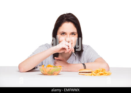 Par rapport à la malbouffe santé concept avec une femme naturelle dans les fruits avant d'attrape et repas avec hamburger frites, isolated on white Banque D'Images