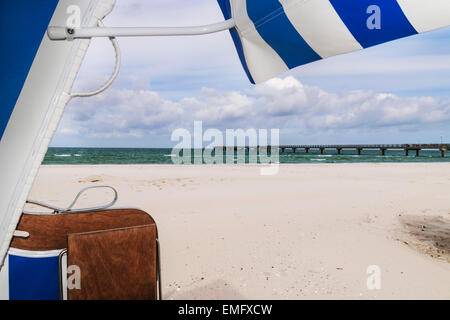 Vue depuis une chaise de plage sur la plage, la mer et une jetée sur la mer Baltique, Allemagne Banque D'Images