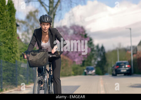 Jeune femme active un trajet en vélo avec casque de protection allant à son bureau Banque D'Images