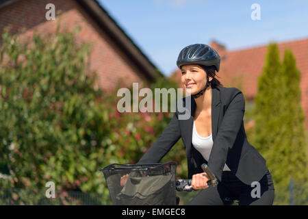 Active Smiling Young Businesswoman Riding a Bicycle with Helmet va à son bureau. Banque D'Images