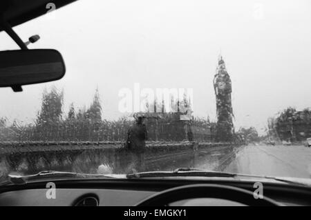 Vue générale de la Maison du Parlement et Big Ben pris par la pluie lavé fenêtre d'une voiture. 28 novembre 1976. Banque D'Images