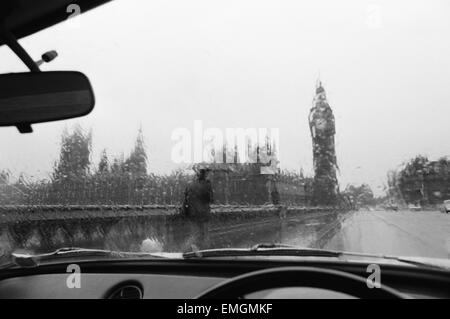 Vue générale de la Maison du Parlement et Big Ben pris par la pluie lavé fenêtre d'une voiture. 28 novembre 1976. Banque D'Images