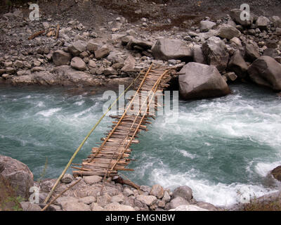 Pont en bois traditionnel plus de ruisseau de montagne Himalaya Lukla au Népal en Asie. Précaire rachitique Banque D'Images