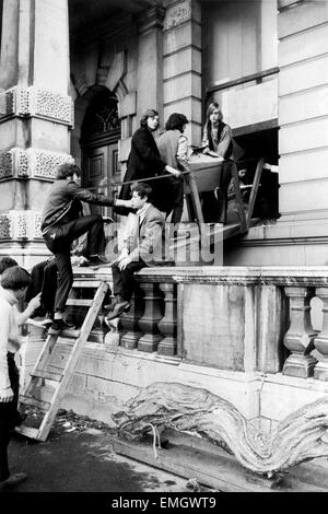 Numéro 144 Piccadilly, un quartier chic de 100 chambres d'hôtel particulier dans le West End de Londres a été occupé par les soi-disant London Street Commune qui affirment qu'ils agissent pour des familles sans abri. Sur la photo, une partie des hippies déménagement dans une boîte d'effets personnels sur leur pont-levis improvisés. 17 septembre 1969. Banque D'Images