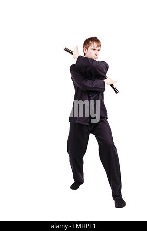 L'homme dans un kimono de kung fu pratique avec nunchaku Banque D'Images