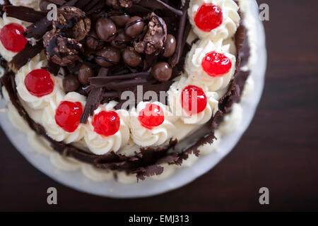 Gâteau au chocolat avec la crème et les cerises. Banque D'Images