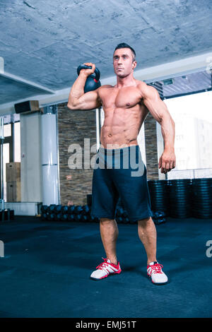 Portrait d'un bodybuilder beau avec entraînement électrique balle en gym crossfit Banque D'Images