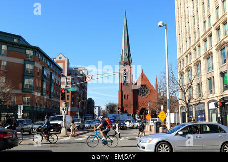 Ville de Cambridge Street les navetteurs à vélo et en voiture pass First Baptist Church spire, Cambridge, Massachusetts, USA. Banque D'Images