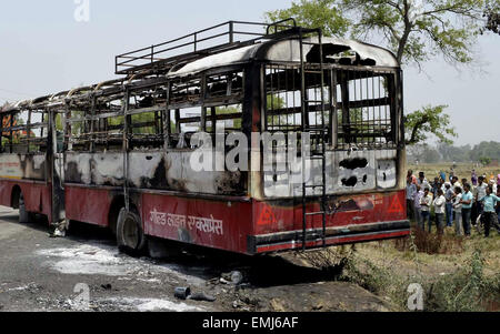 Amethi, Inde. Apr 21, 2015. Les sections locales se rassemblent près d'un bus de voyageurs endommagé qui a pris feu à Peeparpur Amethi en région, à 150 kilomètres de la capitale de l'état de l'Uttar Pradesh, l'Inde, Lucknow, le 21 avril 2015. Au moins neuf personnes ont été brûlée à mort et six autres ont subi des brûlures après un bus qui a pris feu dans le nord de l'état indien de l'Uttar Pradesh Mardi, un haut responsable de la police a dit. Credit : Stringer/Xinhua/Alamy Live News Banque D'Images