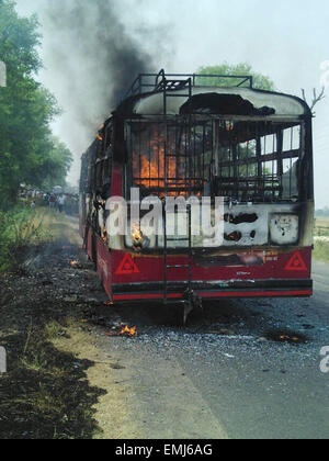 Amethi, Inde. Apr 21, 2015. Les flammes et la fumée sort d'un bus de passagers qui ont pris feu à Peeparpur Amethi en région, à 150 kilomètres de la capitale de l'état de l'Uttar Pradesh, l'Inde, Lucknow, le 21 avril 2015. Au moins neuf personnes ont été brûlée à mort et six autres ont subi des brûlures après un bus qui a pris feu dans le nord de l'état indien de l'Uttar Pradesh Mardi, un haut responsable de la police a dit. Credit : Stringer/Xinhua/Alamy Live News Banque D'Images