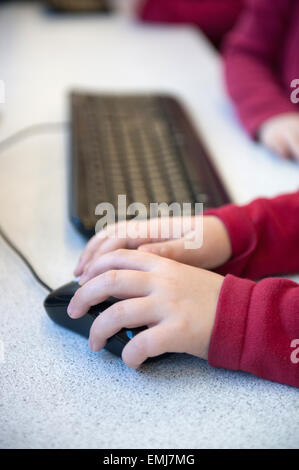 À l'aide d'un écolier britannique la souris et le clavier dans une leçon sur les TIC à l'école Banque D'Images