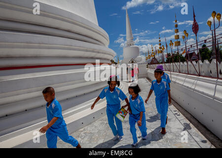 Les enfants de l'école principale encercler stupa de Wat Phra Mahathat Woromaha Vihan, la plus ancienne, plus important dans le sud de la Thaïlande chedi. Banque D'Images