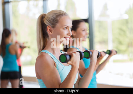 Groupe de femmes exerçant avec haltères en salle de sport Banque D'Images