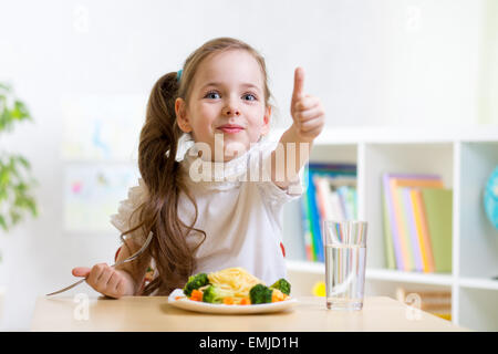 Enfant mange des aliments sains showing thumb up Banque D'Images