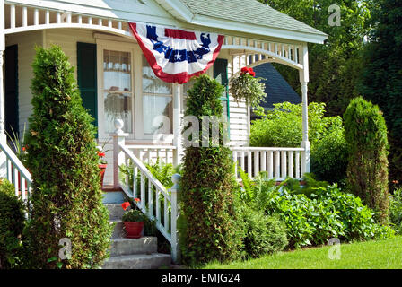 Ancienne ferme avec patriotic American flag bunting en été. Banque D'Images