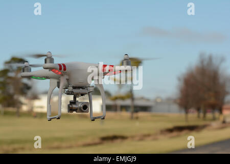 Drone aérien fantôme volant à proximité d'un parc. Quadracopter aérienne contrôlé à distance en vol ciel bleu. Banque D'Images